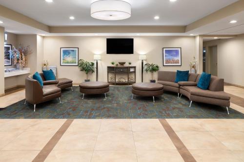 a waiting room with couches and a flat screen tv at Candlewood Suites Philadelphia - Airport Area by IHG in Chester