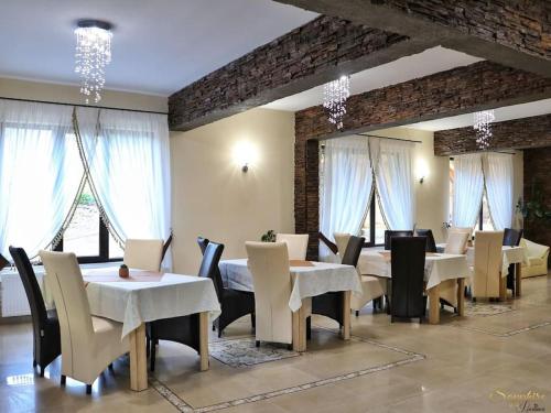 Sapphire Chalet-un cadru elegant في موياشيو دي سوس: غرفة طعام مع طاولات بيضاء وكراسي ونوافذ