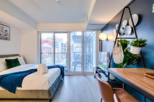 Panorama Suites Downtown Toronto في تورونتو: غرفة نوم بسرير ومكتب ونافذة