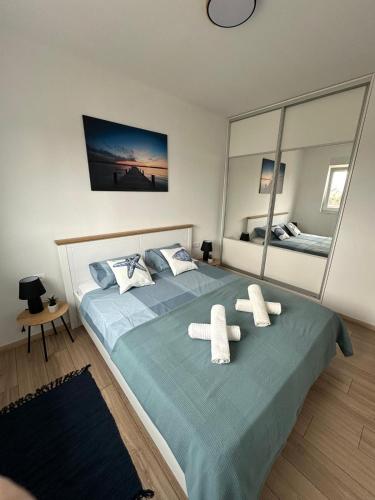 a bedroom with a large bed with two white towels at Apartment Mila in Ugljan