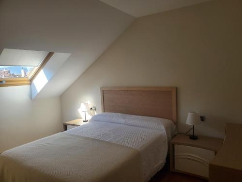 1 dormitorio con cama blanca y ventana en ÁTICO DE LUJO TRANQUILO En LA PLAYA, en Arcade