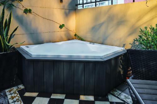a bath tub sitting on top of a tiled floor at Miravida Soho Hotel & Wine Bar in Buenos Aires