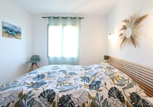 ein Schlafzimmer mit einem Bett mit einer bunten Bettdecke in der Unterkunft La maison des cerisiers in Bédoin