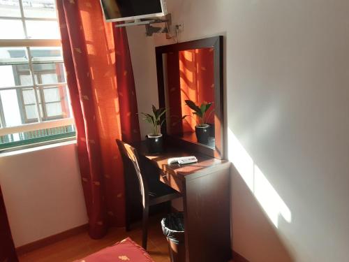 a dressing table with a mirror and a chair at Residência Machado in Horta