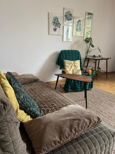 a bedroom with a bed and a chair and a table at Wilson Apartment in Warsaw