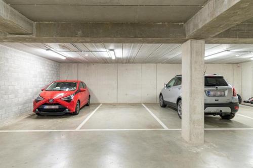 a parking garage with two cars parked in it at High Standing Suites Premium in Liège in Liège