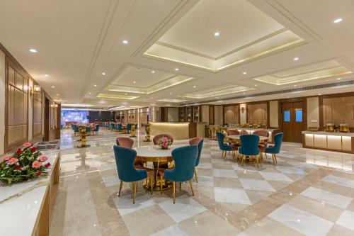 a lobby of a hotel with tables and chairs at Sandoz Amritsar - Lawrence Road in Amritsar