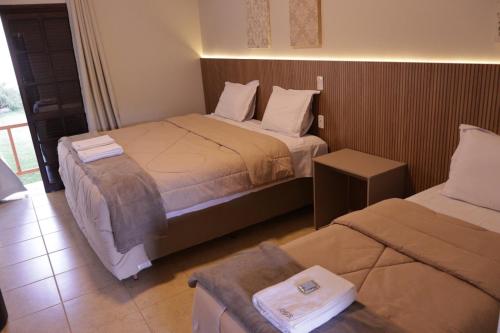 ein Hotelzimmer mit 2 Betten und einem Balkon in der Unterkunft Pousada Apear in Andradas