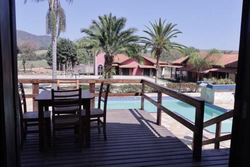 - un balcon avec une table et des chaises à côté de la piscine dans l'établissement Pousada Apear, à Andradas