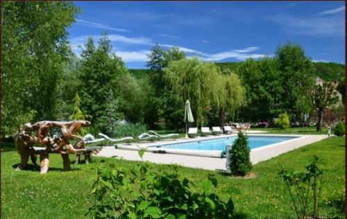 - une piscine avec un banc dans l'herbe à côté dans l'établissement Les Trois Faisans, à Bligny-sur-Ouche