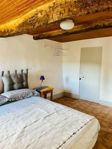 une chambre avec un grand lit avec un plafond en bois dans l'établissement Lou Raspaioun - Coeur du village, à Correns