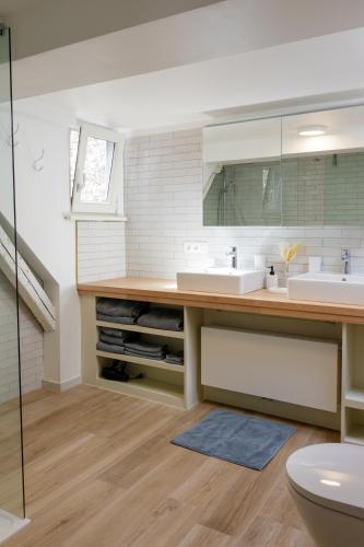 a bathroom with two sinks and a mirror at LE NID DU PRINCE in Bruges