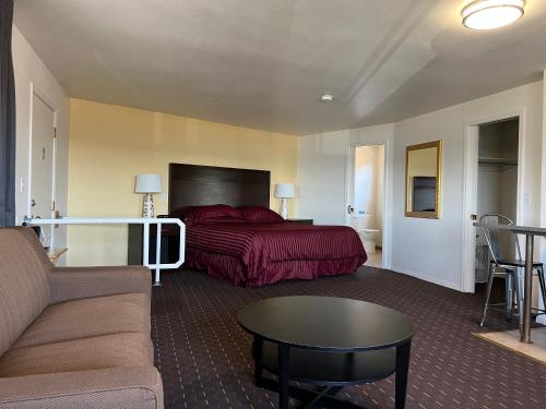 a bedroom with a bed and a couch and a table at Port Townsend Inn in Port Townsend