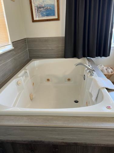 a white bath tub in a bathroom with a window at Port Townsend Inn in Port Townsend
