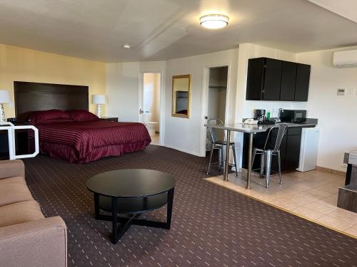 Habitación de hotel con cama y sala de estar. en Port Townsend Inn, en Port Townsend