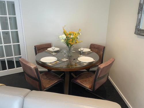a dining room table with chairs and a vase of flowers at Highthel Holiday Home by the Northumberland Coast in Morpeth