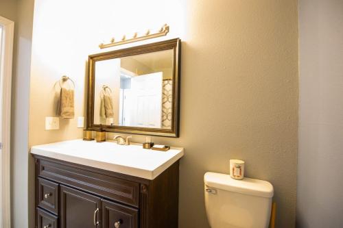 a bathroom with a sink and a mirror and a toilet at 3 Bedroom Family Friendly Home in Anchorage