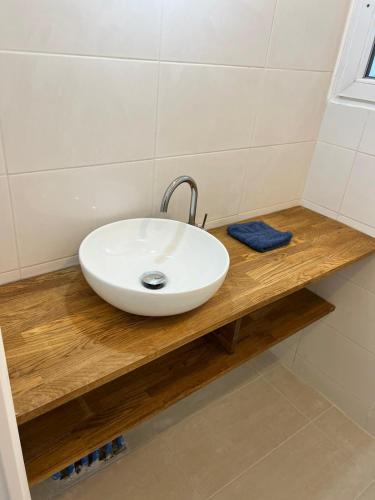 un lavabo blanc sur un comptoir en bois dans une salle de bain dans l'établissement T2 Colombes proche toutes commodités #4, à Colombes
