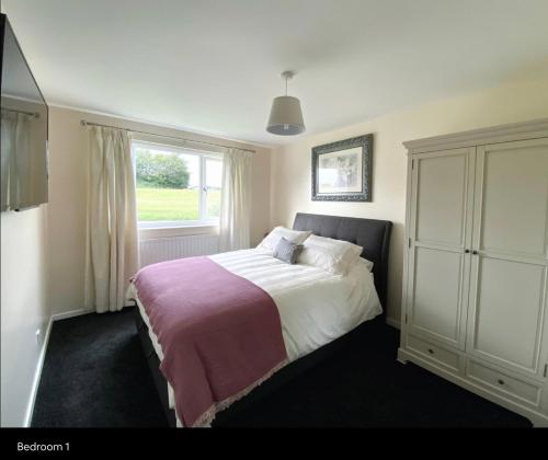 a bedroom with a large bed and a window at Highthel Holiday Home by the Northumberland Coast in Morpeth
