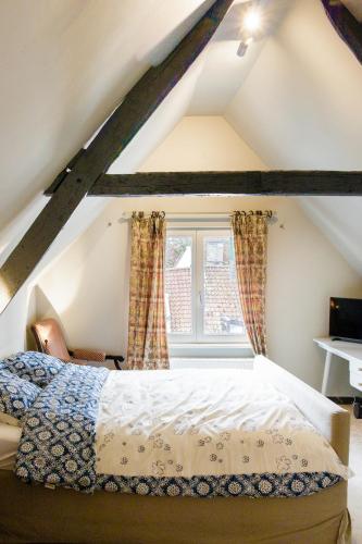 a bedroom with a bed and a window at LE NID DU PRINCE in Bruges