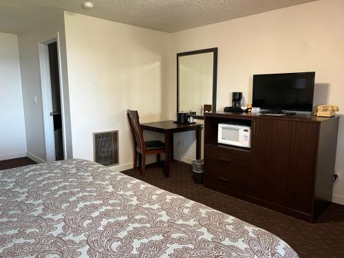 a hotel room with a bed and a desk and a television at Port Townsend Inn in Port Townsend