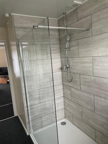 a shower with a glass door in a bathroom at Highthel Holiday Home by the Northumberland Coast in Morpeth