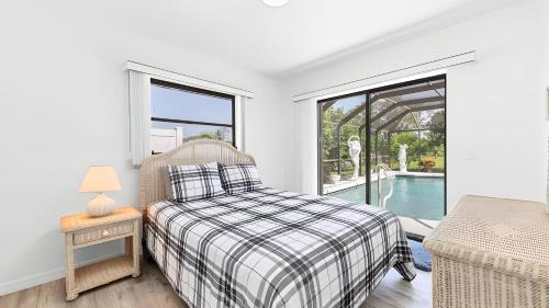 a bedroom with a bed and a glass door to a pool at New house 3-room pool lake view in Port Charlotte