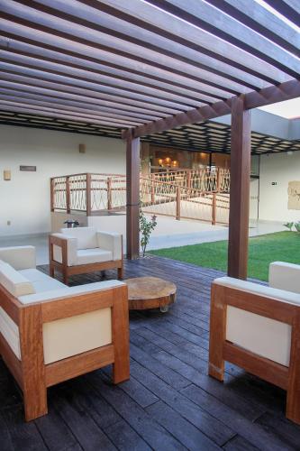 a pavilion with couches and tables on a wooden deck at HOTEL SERRA DA CAPIVARA RESORT E CONVENTION in São Raimundo Nonato