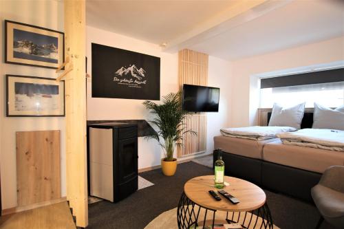 a living room with a bed and a couch and a table at Westerwald Apartment DRIE600 in Driedorf