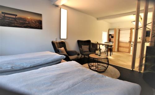 una camera d'albergo con due letti e un tavolo con sedie di Westerwald Apartment DRIE600 a Driedorf