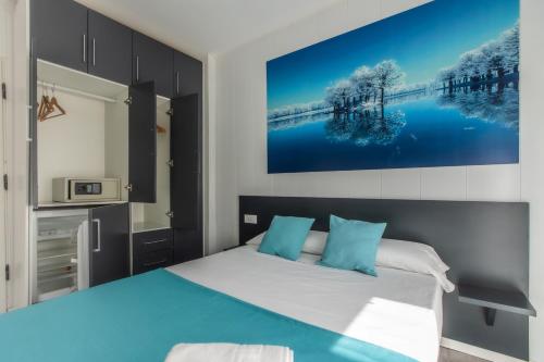 een slaapkamer met een bed en een schilderij aan de muur bij Estudio con balcones 2ºA playa76 in Torremolinos