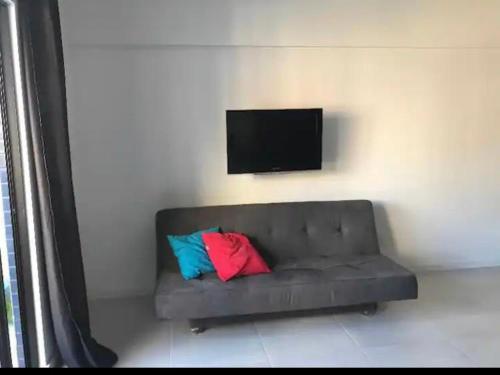 - un canapé avec deux oreillers colorés dans l'établissement Apartamento studio, à Maceió