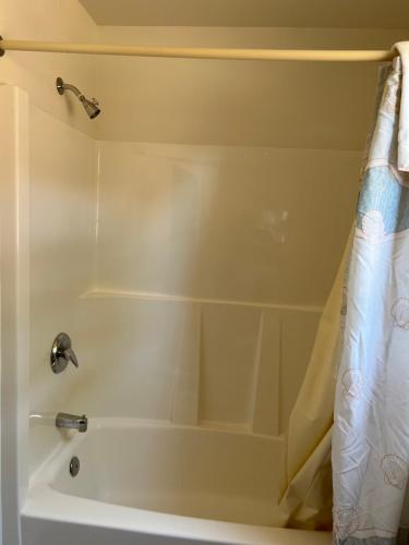 a bath tub with a shower curtain in a bathroom at Port Townsend Inn in Port Townsend