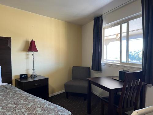 a hotel room with a desk and a bed and a window at Port Townsend Inn in Port Townsend
