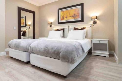 1 dormitorio con 1 cama blanca grande y 2 lámparas en 522 The Granger en Ciudad del Cabo