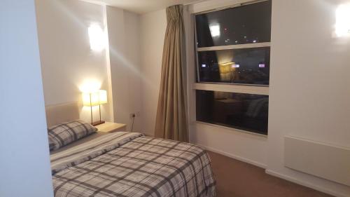 Rúm í herbergi á Excellent Excel/Stratford Apartment