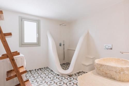 a white bathroom with a sink and a tub at Mykonos Lagom in Mikonos