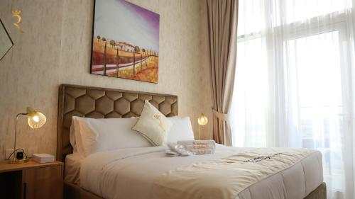 a bedroom with a white bed with a large window at Jupiter 1BR Apartment - Contemporary Living in Oasis, Near Louvre Abu Dhabi in Abu Dhabi