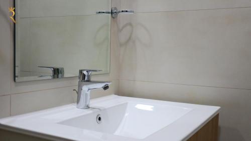 a bathroom with a sink and a mirror at Jupiter 1BR Apartment - Contemporary Living in Oasis, Near Louvre Abu Dhabi in Abu Dhabi