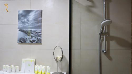 a bathroom with a shower with a mirror and a sink at Jupiter 1BR Apartment - Contemporary Living in Oasis, Near Louvre Abu Dhabi in Abu Dhabi