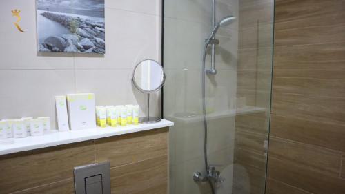 a bathroom with a glass shower with a mirror at Jupiter 1BR Apartment - Contemporary Living in Oasis, Near Louvre Abu Dhabi in Abu Dhabi