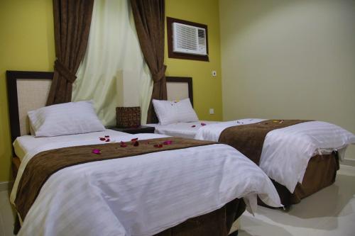 two beds in a room with flowers on them at أندلسية الوسام in Taif