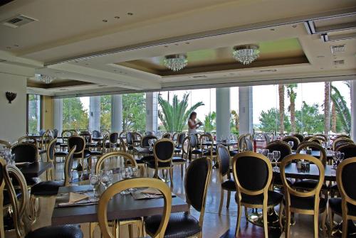 a banquet hall with tables and chairs and a person in the background at Mediterranean Princess- Adults Only in Paralia Katerinis
