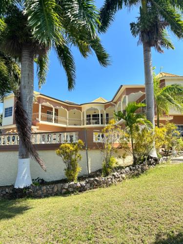 a large building with palm trees in front of it at Ocean Sight Villa in Montego Bay