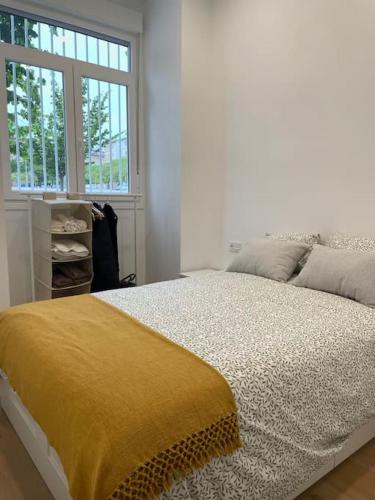 a bedroom with a bed with a yellow blanket on it at Nidito Enamorados in Pamplona