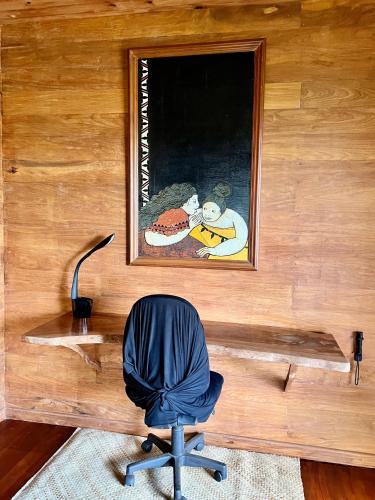 a desk with a chair and a picture on a wall at Fare Hotu Villa in Fitii