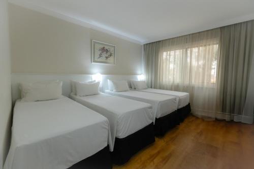 a hotel room with two beds and a window at Hotel Premium Campinas in Campinas