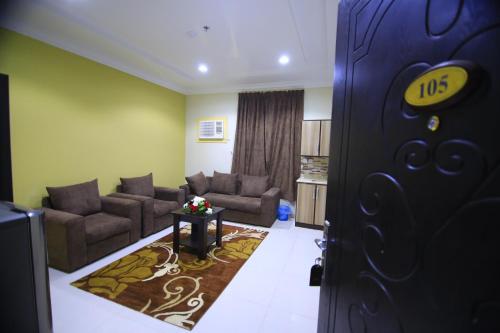 a living room with two couches and a door at أندلسية الوسام in Taif