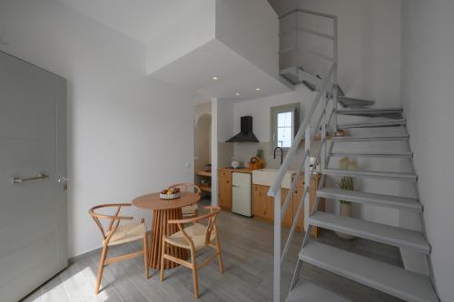 a kitchen and dining room with a staircase and a table at Aegean Diamonds Luxury Suites in Monolithos