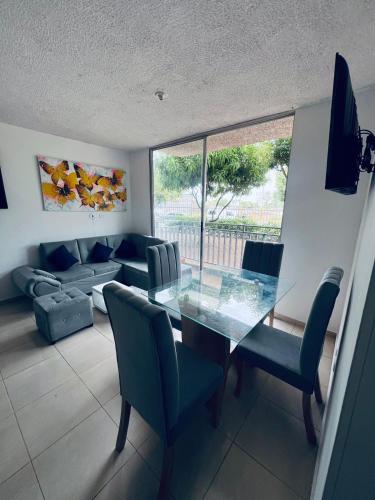 a dining room with a glass table and chairs at ESTANCIA MINIMA 3 NOCHES APARTAMENTO 3 HABITACIONES - 5 PERSONAS no aire acondicionado in Valledupar
